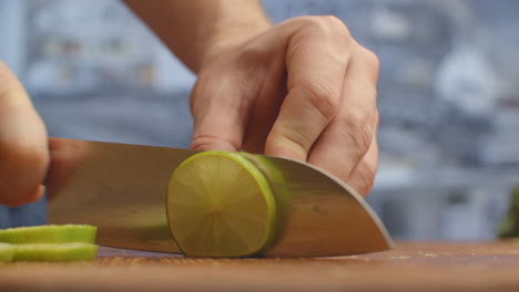 Cut-with-a-knife-on-a-wooden-board-closeup-green-lime-in-the-kitchen.-shred